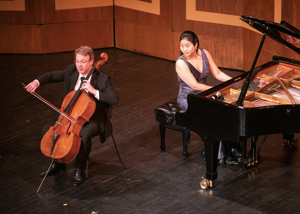 Hyeyeon Park plays piano while looking at Dmitri Atapine playing cello. 