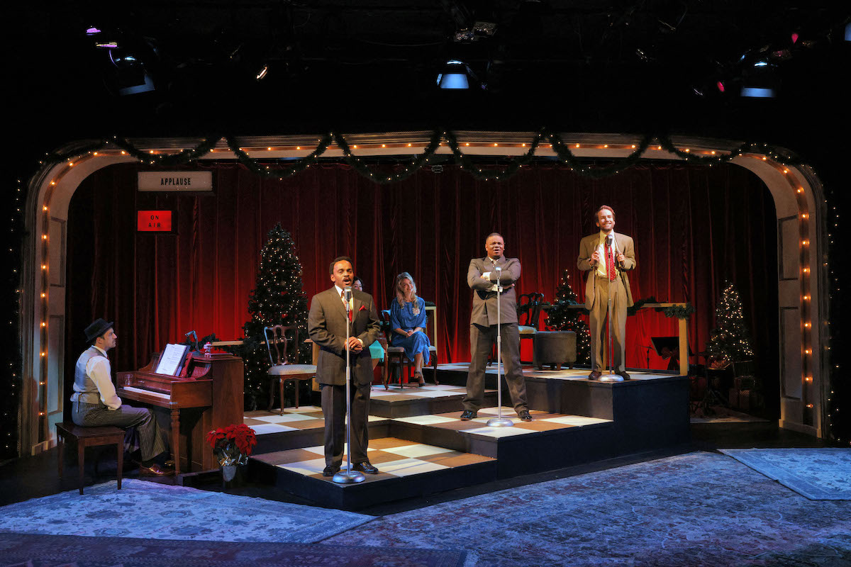 A group of actors perform a live radio play on a stage.