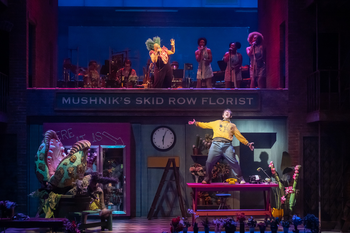 The cast of Little Shop of Horrors performs.