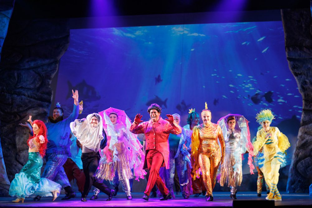 A cast dressed as sea creatures dances.