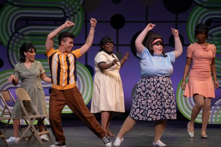 Young actors dance in a scene from Hairspray.