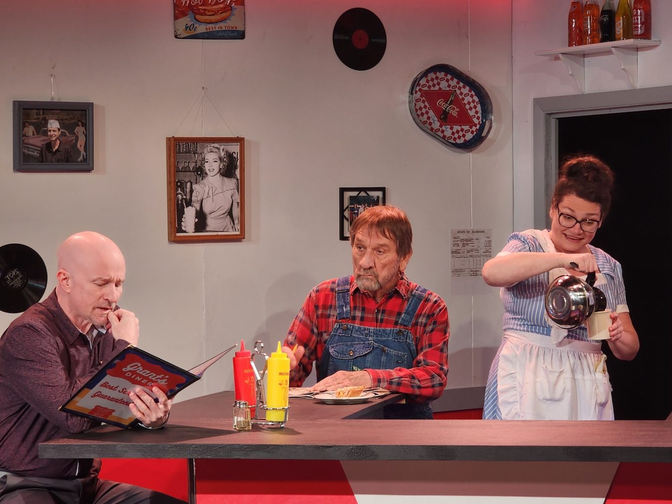 Three actors performing a scene in a classic diner.